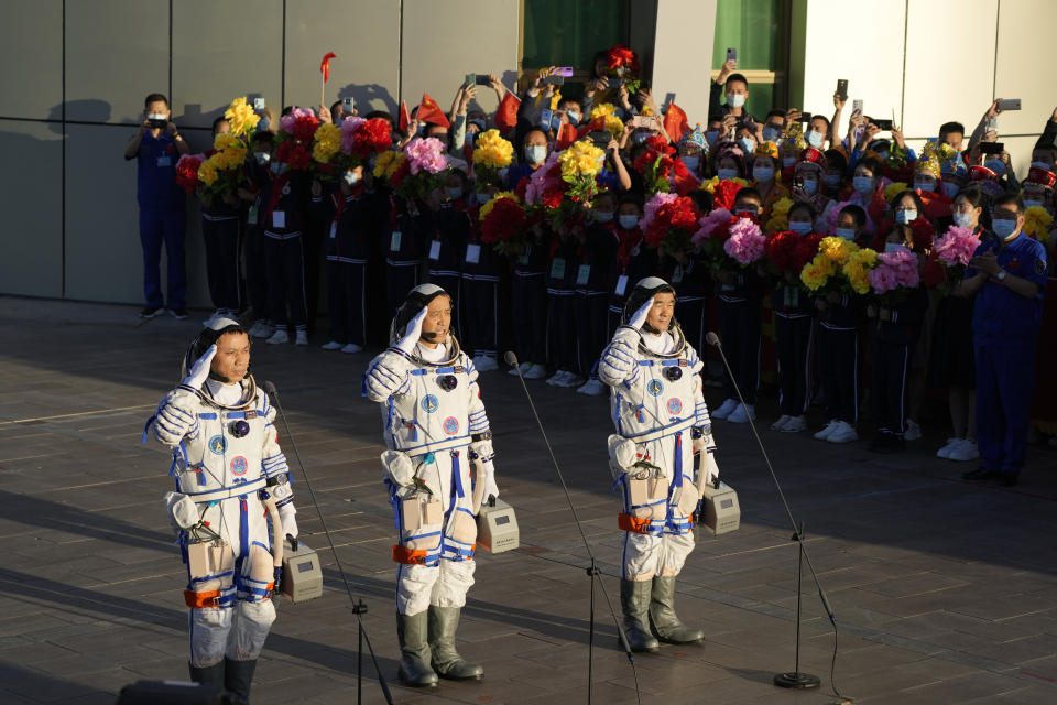 Chinese astronauts, from left, Tang Hongbo, Nie Haisheng, and Liu Boming salute as they prepare to board for liftoff at the Jiuquan Satellite Launch Center in Jiuquan in northwestern China, Thursday, June 17, 2021. China plans on Thursday to launch three astronauts onboard the Shenzhou-12 spaceship who will be the first crew members to live on China's new orbiting space station Tianhe, or Heavenly Harmony. (AP Photo/Ng Han Guan)