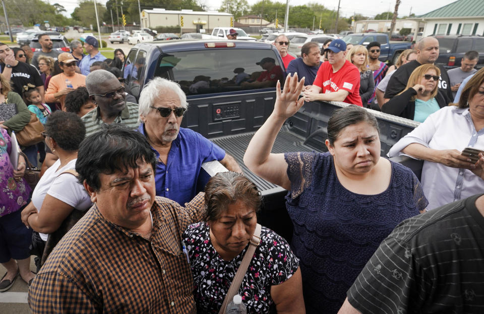 Jessica Leija holds up her hand to ask a question as Bill Ogden, a lawyer with Farrar & Ball, talks to a crowd of Deer Park residents Saturday, March 23, 2019, outside where he and Chance McMillan, founding partner of the McMillan Law Firm, were suppose to host a town hall-style meeting about the legal ramifications stemming from the recent ITC fire, in Deer Park, Texas. The crowd was to large to accommodate inside. (Melissa Phillip/Houston Chronicle via AP)