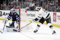 Los Angeles Kings center Phillip Danault (24), right, assists on a goal by left wing Alex Iafallo past Winnipeg Jets goaltender Connor Hellebuyck (37) during the second period of an NHL hockey game Saturday, March 25, 2023, in Los Angeles. (AP Photo/Marcio Jose Sanchez)