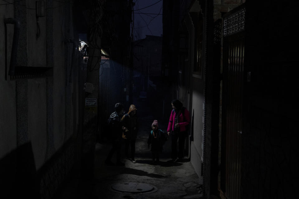 Kashmiri children walk back home after attending private tuition during a power outage on a cold evening in Srinagar, Indian controlled Kashmir, Wednesday, Dec. 27, 2023. Residents have long accused New Delhi of stifling their hydropower potential, as most of such power produced locally goes to various Indian states, leaving 13% for Kashmir. The region must purchase electricity at higher prices from India's northern grid to meet demand. (AP Photo/Dar Yasin)