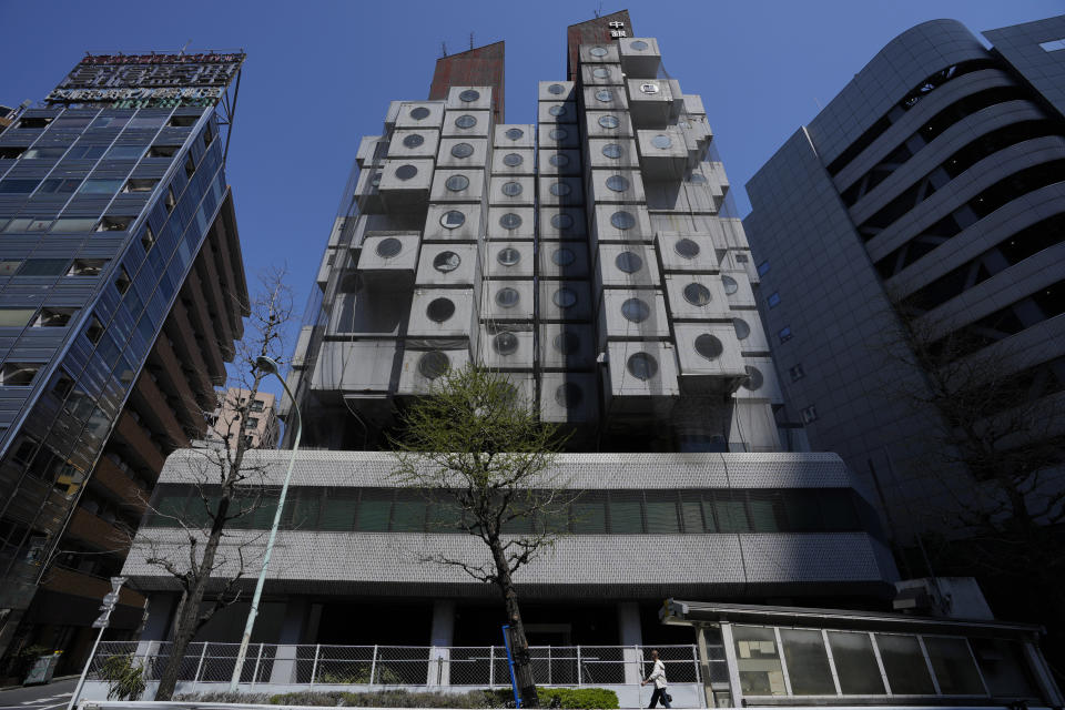 The Nakagin Capsule Tower, a famed capsule hotel in the Ginza district, shows its unique architecture of small cubic rooms, as parts of the capsule hotel was being demolished, in Tokyo on April 8, 2022. It’s now being demolished in a careful process that includes preserving some of its 140 capsules, to be shipped to museums around the world. (AP Photo/Hiro Komae)