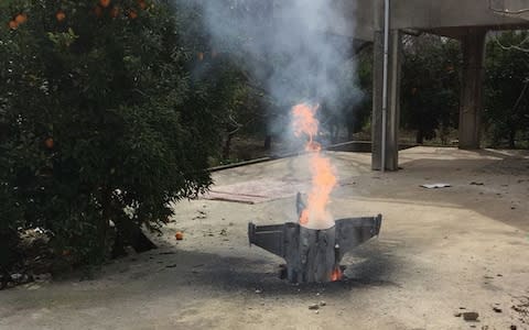 Flames rise from a missile, which according to the Lebanon national news agency appears to be part of a Syrian air defense missile targeting an Israeli warplane which landed in a lemon grove, in Hasbani village, southwest Lebanon - Credit: AP