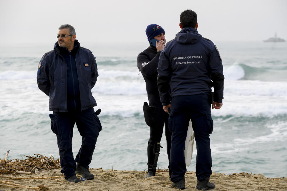 Italian Coast Guard officers stand by as rescue crews search for people believed still missing from a migrant shipwreck close to a beach near Cutro, southern Italy, Monday, Feb. 27, 2023. Rescue crews searched by sea and air Monday for the dozens of people believed still missing from a shipwreck off Italy’s southern coast that drove home once again the desperate and dangerous crossings of migrants seeking to reach Europe. (AP Photo/Valeria Ferraro)