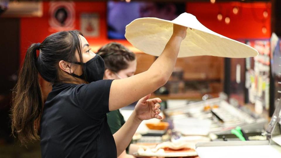 Chriatina Dickson, shift manager at Woodstock’s, tosses pizza dough on Wednesday, Jan. 12. The restaurant is looking to hire new workers amid a national labor shortage and the coronavirus pandemic that have left the San Luis Obispo eatery short staffed.