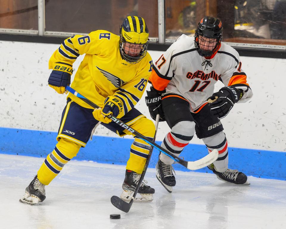 Hartland's Ian Kastamo (16) battles Houghton's Connor Raffaelli (17) for the puck during the Eagles' season opener Saturday, Nov. 18, 2023.