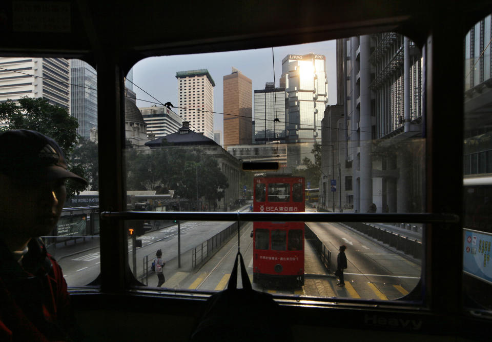 In this Jan. 11, 2013 photo, a man sits on the upper deck of a tram in Central, downtown of Hong Kong. Hop aboard the century-old tram system for an old-fashioned ride through the neighborhoods along the length of the northern edge of the island. (AP Photo/Kin Cheung)