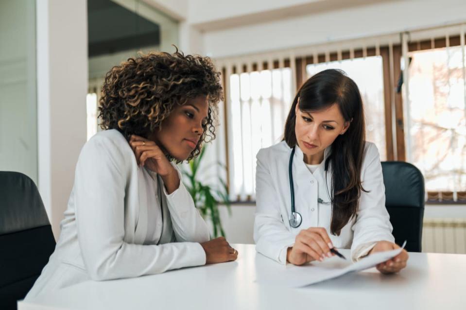 Doctor showing test results to a patient, portrait.