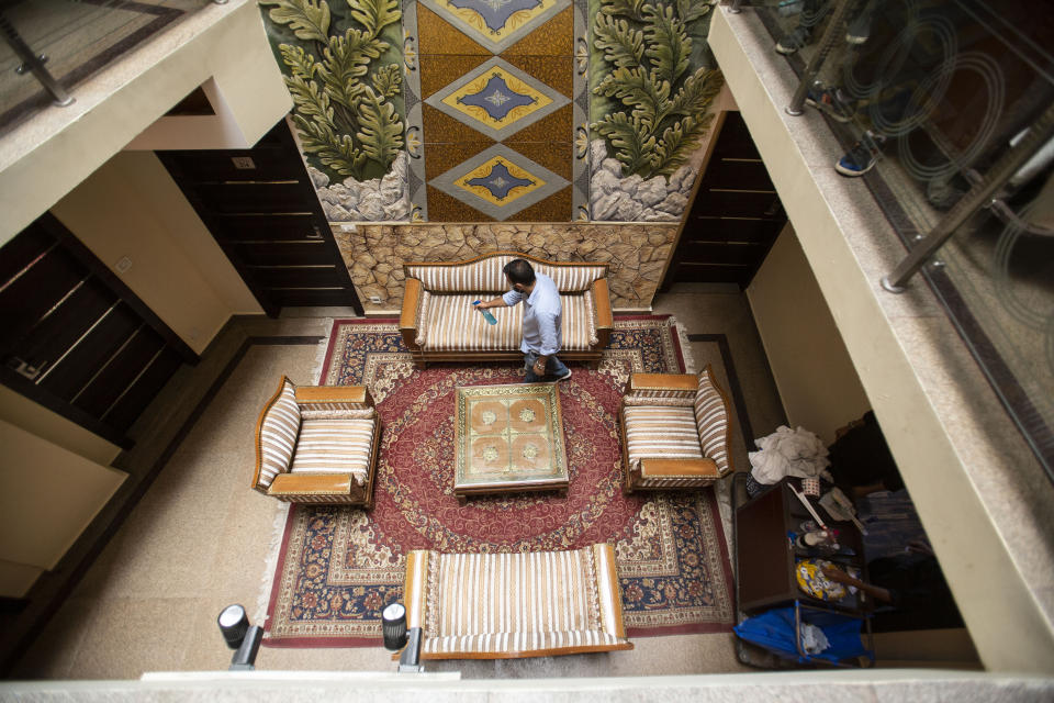 A man sanitizes the interiors of a hotel in Srinagar, Indian controlled Kashmir on Aug. 2, 2021. Tourists are returning to the valleys and mountains in Indian-controlled Kashmir, as infections in the Himalayan region and nationwide come down after a deadly second wave earlier this year. (AP Photo/Mukhtar Khan)