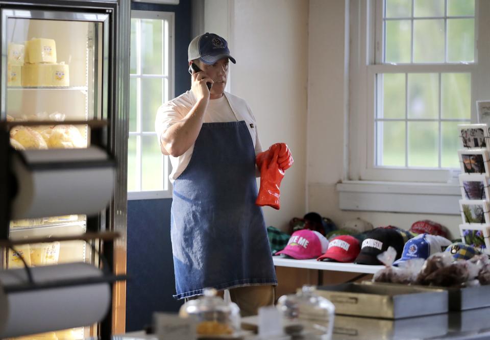 Jon Metzig takes a phone call May 23 near the visitor's entrance of Union Star Cheese Factory.