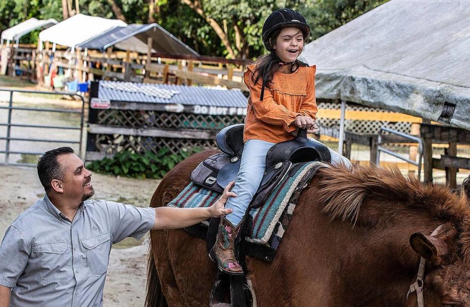 Ronnie López sostiene a su hija Angelina López mientras monta a Sampson, un caballo de la HAPPI Farm. &quot;La primera vez que montó supimos enseguida que este era su lugar feliz&quot;, dijo su madre, Glenda López.