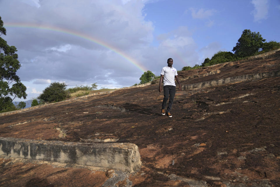 Jefferson Mutie, Africa Sand Dam Foundation communication officer, walks on a water rock catchment system in Makueni County, Kenya on Thursday, Feb. 29, 2024. (AP Photo/Brian Inganga)