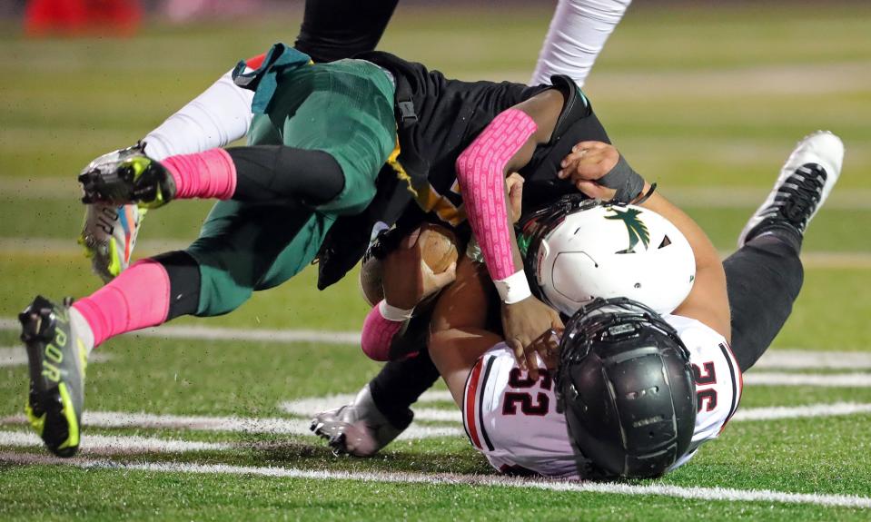 Firestone quarterback Daylyn Taylor, top, is sacked by Buchtel defensive tackle Davian Greenlee during the first half of a high school football game, Friday, Oct. 21, 2022, in Akron, Ohio.