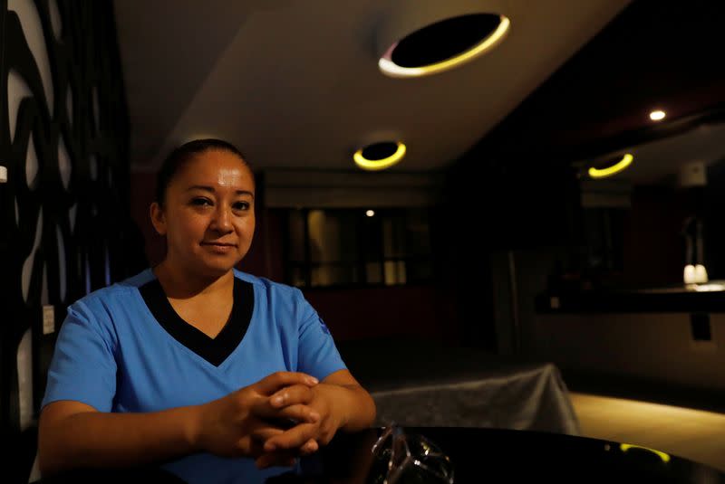 Nurse Gisela Hernandez, who has stayed away from her children for nearly two months to avoid infecting them because she feels inadequately protected, poses for a photograph at her hotel room in Mexico City