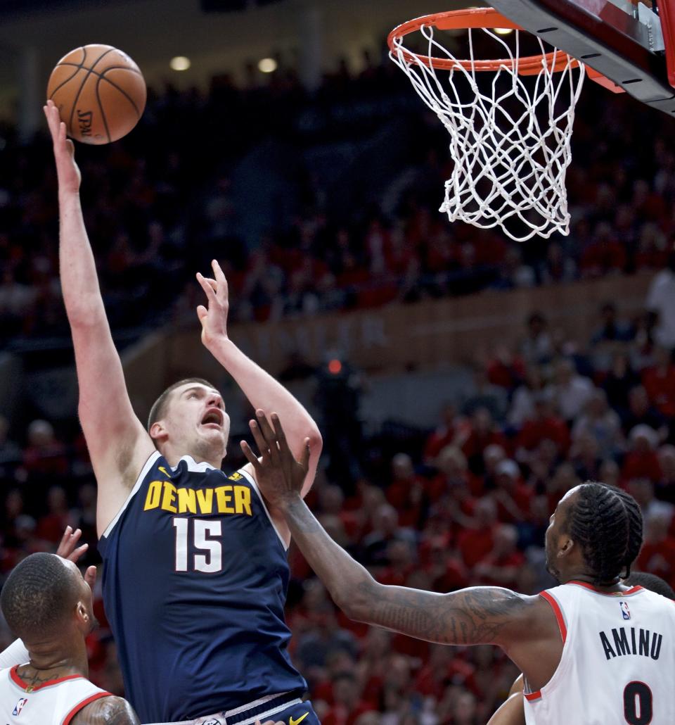 Denver Nuggets center Nikola Jokic, left, shoots over Portland Trail Blazers forward Al-Farouq Aminu during the first half of Game 4 of an NBA basketball second-round playoff series Sunday, May 5, 2019, in Portland, Ore. (AP Photo/Craig Mitchelldyer)