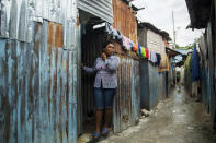 Magdala Louis stands in the doorway of her home in Port-au-Prince, Haiti, Thursday, April 8, 2021. On Dec. 6, 2020, men with automatic weapons kidnapped her and a friend. The two were blindfolded, taken to a house and asked who in their family had money. Eventually, the family of her friend paid for both of their releases, but Louis said she's now too afraid to leave her house to work: “I wish I had died in the (2010) earthquake so as not to have gone through this.” (AP Photo/Odelyn Joseph)