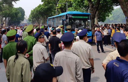 Police stand around a bus after they detained protesters during a demonstration against a draft law on the Special Economic Zone in Hanoi, Vietnam June 10, 2018. REUTERS/Staff