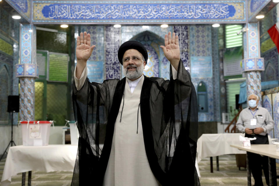 Ebrahim Raisi, a candidate in Iran's presidential elections waves to the media after casting his vote at a polling station in Tehran, Iran Friday, June 18, 2021. Iran began voting Friday in a presidential election tipped in the favor of a hard-line protege of Supreme Leader Ayatollah Ali Khamenei, fueling public apathy and sparking calls for a boycott in the Islamic Republic. (AP Photo/Ebrahim Noroozi)