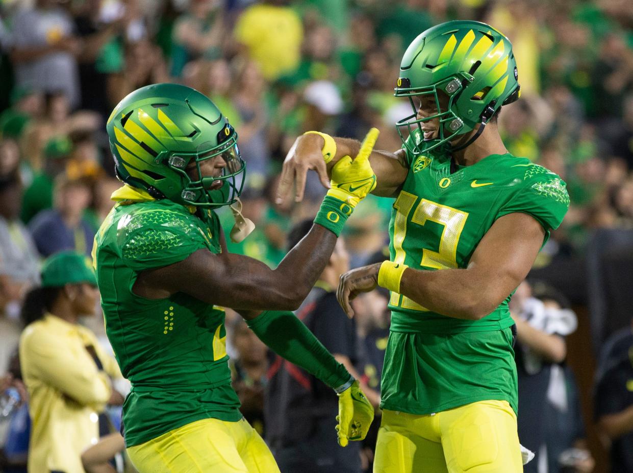 Oregon's Traeshon Holden, left, and quarterback Ty Thompson celebrate a fourth quarter touch down against Hawaii in Eugene, Ore. Sept. 16, 2023.