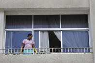 In this Saturday, May 23, 2020 photo, an Ethiopian domestic worker cleans her employer's balcony, in Beirut, Lebanon. Some 250,000 registered migrant laborers in Lebanon — maids, garbage collectors, farm hands and construction workers — are growing more desperate as a crippling economic and financial crisis sets in, coupled with coronavirus restrictions. With no functioning airports and exorbitant costs of repatriation flights, many are trapped, unable to go home. (AP Photo/Hussein Malla)