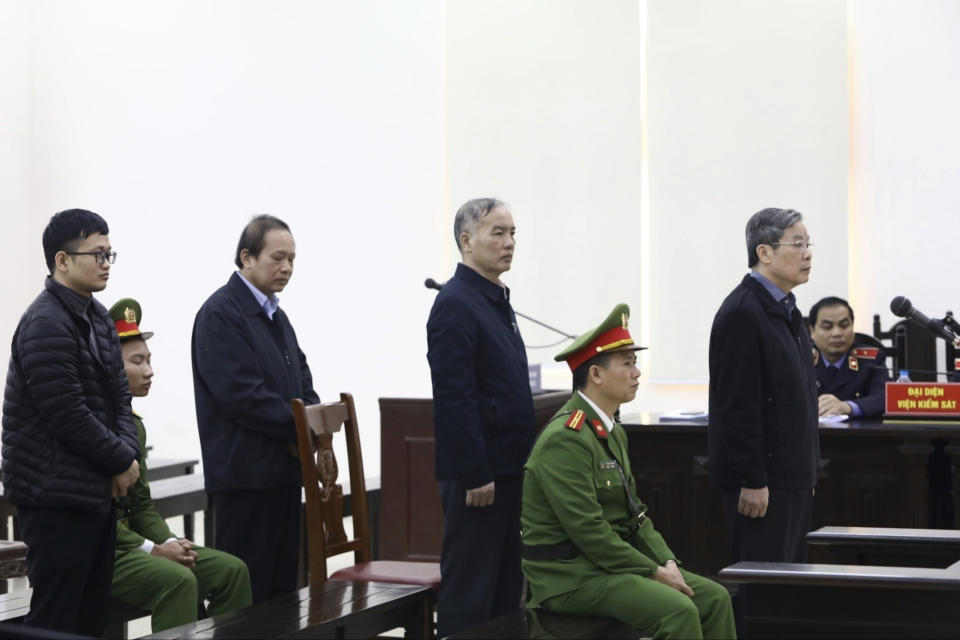 Vietnamese former minister of information and communication Nguyen Bac Son, right, former Mobifone Chairman Le Nam Tra, second right, former Minister of information and communication Truong Minh Tuan, second left, and valuer Hoang Duy Quang, left, stand as judge reads the verdicts at their trial in Hanoi, Vietnam Saturday, Dec. 28, 2019. Hanoi court on Saturday sentenced Son to life imprisonment in a multi-million dollar corruption case that also saw another minister and a dozen executives receive lengthy prison terms. (Nguyen Van Diep/VNA via AP)