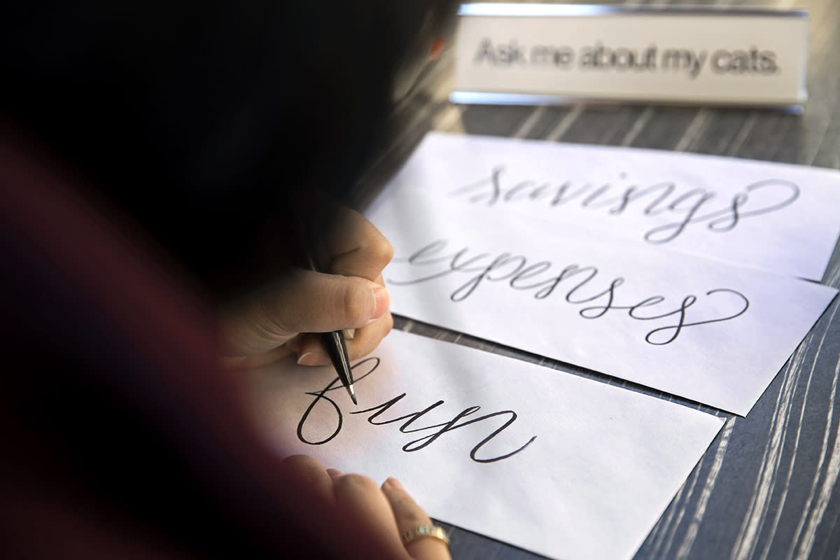 A person creates three different envelopes for savings, fun and expenses. This is part of the envelope method