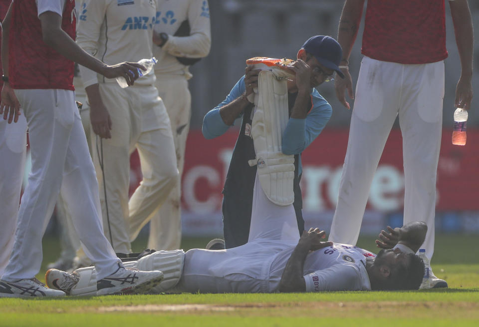 India's Mayank Agarwal is attended by team Physiotherapist Nitin Patel during the day one of second test cricket match against New Zealand in Mumbai, India, Friday, Dec. 3, 2021.(AP Photo/Rafiq Maqbool)