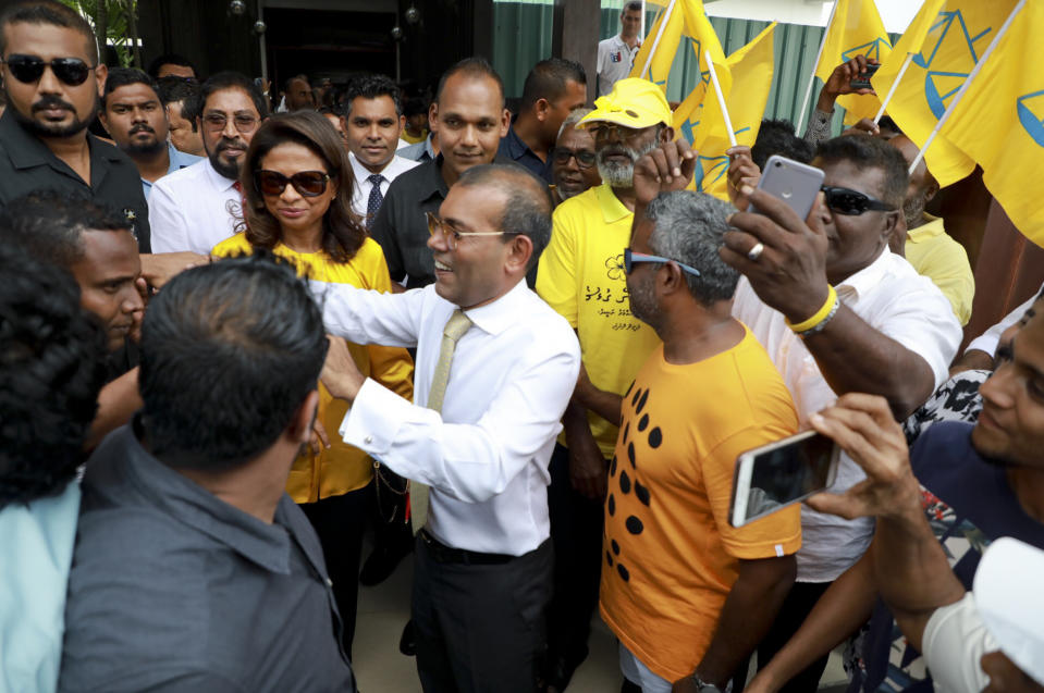 Maldives’ former president Mohamed Nasheed, center, greets supporters and party workers upon arrival at the airport in Male, Maldives, Thursday, Nov.1, 2018. Nasheed, the first democratically elected president of the Maldives returned home after more than two years in exile to escape a long prison term. (AP Photo/Mohamed Sharuhaan)