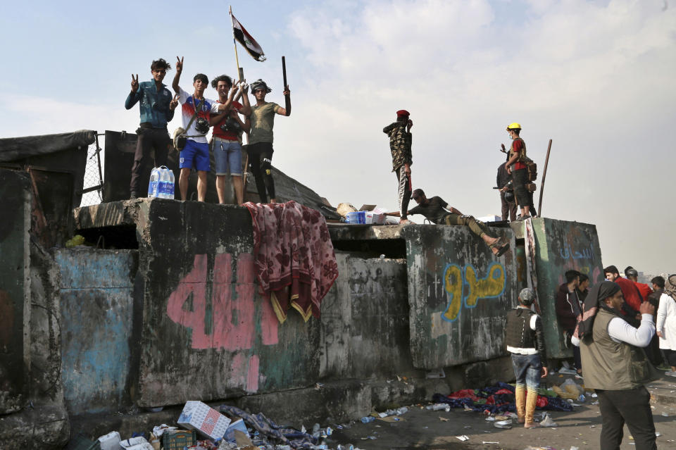 Protesters stage a sit-in on barriers at the Ahrar Bridge during ongoing anti-government protests in Baghdad, Iraq, Wednesday, Nov. 27, 2019. Several protesters were killed by security forces who fired live rounds in Baghdad and southern Iraq amid ongoing violence and days of sit-ins and road closures, Iraqi officials said Wednesday. (AP Photo/Khalid Mohammed)