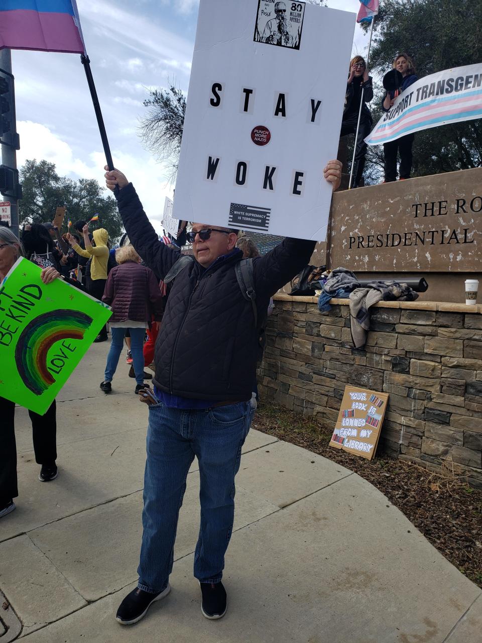 Oxnard resident Michael McKeon holds a rainbow pride flag and a protest sign that says "Stay Woke" at a protest against Florida Gov. Ron DeSantis who spoke at the Ronald Reagan Presidential Library & Museum in Simi Valley on Sunday, March 5, 2023.