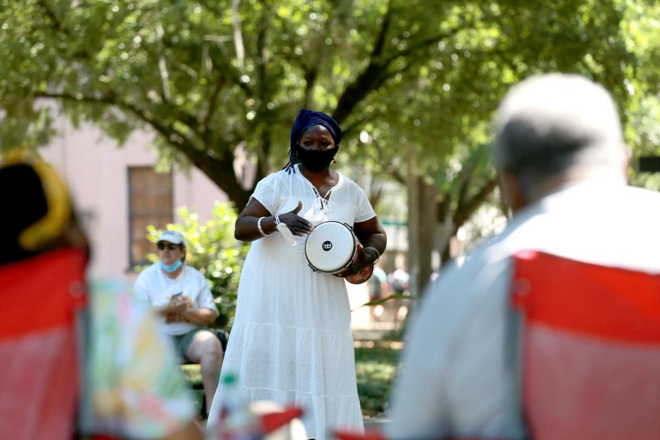 Patt Gunn plays the drum at Calhoun Square during a "Come Sunday!" event.