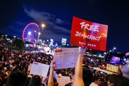 Demonstrators hold placards during a rally ahead of the G20 summit, urging the international community to back their demands for the government to withdraw a the extradition bill in Hong Kong