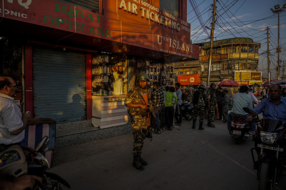 An Indian paramilitary soldier guards at a busy market in Srinagar, Indian controlled Kashmir, Tuesday, Aug 1, 2023. India’s top court Wednesday began hearing a clutch of petitions challenging the constitutionality of the legislation passed by Prime Minister Narendra Modi’s government in 2019 that stripped disputed Jammu and Kashmir’s statehood, scrapped its separate constitution and removed inherited protections on land and jobs. (AP Photo/Mukhtar Khan)