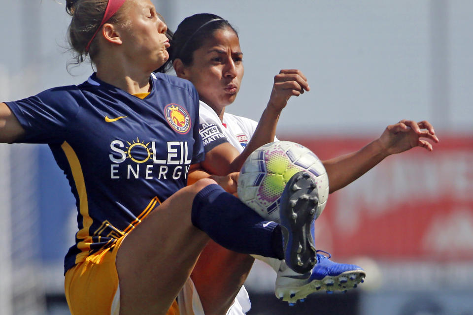 FILE - Utah Royals FC defender Madeline Nolf, left, battles with OL Reign midfielder Shirley Cruz, rear, during the first half of an NWSL Challenge Cup soccer match at Zions Bank Stadium, Wednesday, July 8, 2020, in Herriman, Utah. The Royals are returning to Utah and the National Women's Soccer League. The NWSL and Major League Soccer's Real Salt Lake announced the second iteration of the Utah Royals on Saturday, March 11, 2023.. The Royals were part of the NWSL for three seasons from 2018 to 2020. (AP Photo/Rick Bowmer, File)