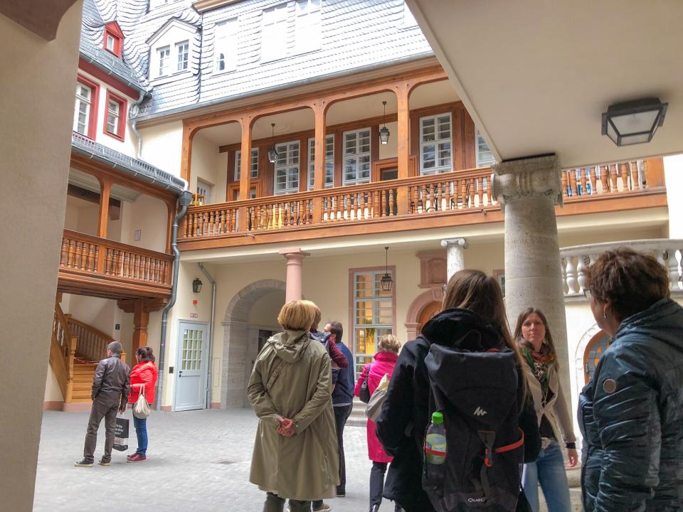 A tour group visits a courtyard area in Frankfurt’s reconstructed DomRömer Quarter, where local residents live in newly finished homes. There have been clashes between tourists and residents of these homes, who have asked tour guides to keep their groups quiet.
