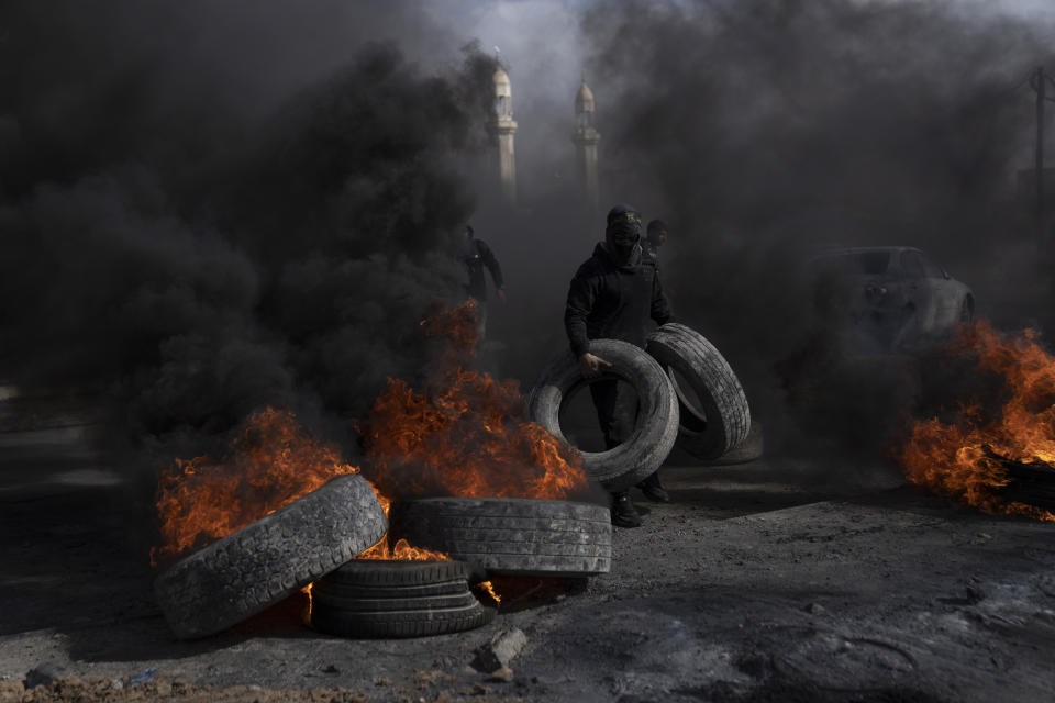 Palestinian protesters block the main road with burning tires in the West Bank city of Jericho, Monday, Feb. 6, 2023. Israeli forces killed five Palestinian gunmen in a raid on a refugee camp in the occupied West Bank on Monday, the latest bloodshed in the region that will likely further exacerbate tensions. (AP Photo/Nasser Nasser)