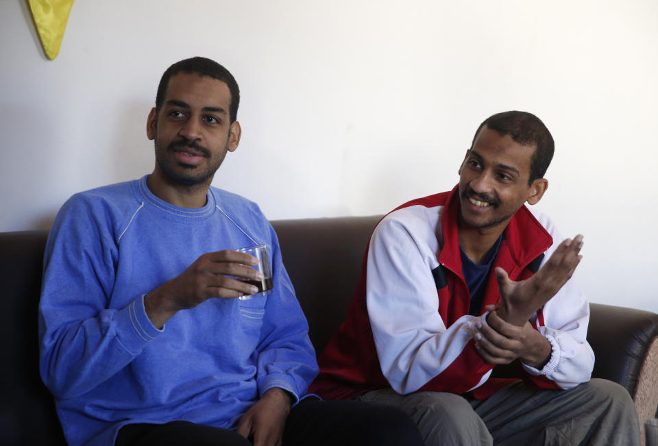 FILE - In this March 30, 2018, file photo, Alexanda Amon Kotey, left, and El Shafee Elsheikh, who were allegedly among four British jihadis who made up a brutal Islamic State cell dubbed "The Beatles," speak during an interview with The Associated Press at a security center in Kobani, Syria. The men said that their home country's revoking of their citizenship denies them a fair trial. "The Beatles" terror cell is believed to have captured, tortured and killed hostages including American, British and Japanese journalists and aid workers. (AP Photo/Hussein Malla, File)