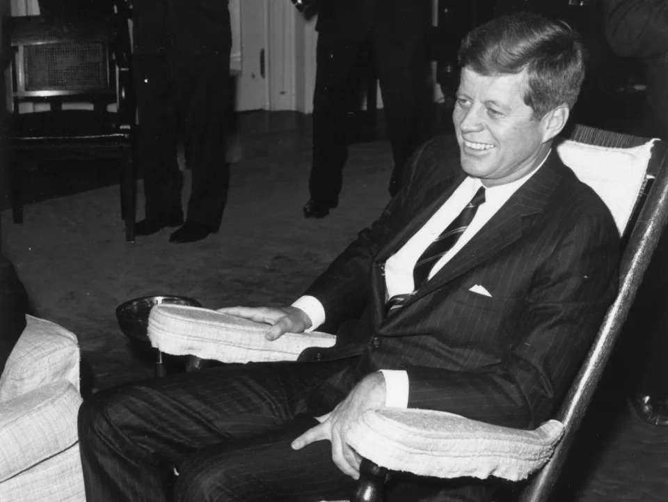 John F. Kennedy poses for photographers in his favorite rocking chair in the White House in 1963.