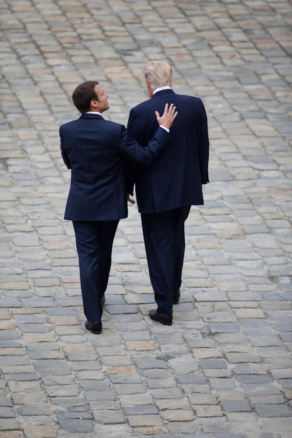 FILE - In this July 13, 2017, file photo, French President Emmanuel Macron and U.S. President Donald Trump, right, walk in the courtyard of the Invalides in Paris. France wants the D-Day commemoration to showcase its long friendship with the U.S., but relations are strained as Trump and Macron prepare to meet Thursday, June 6, 2019. (AP Photo /Matthieu Alexandre, File)