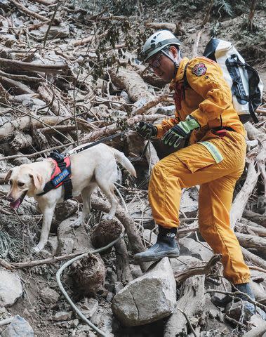 <p>CNA/AFP via Getty Images</p> Roger during search and rescue efforts on April 5