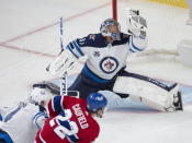 Winnipeg Jets goaltender Connor Hellebuyck (37) makes a glove save on Montreal Canadiens' Cole Caufield during the second period of an NHL Stanley Cup playoff hockey game in Montreal, Sunday, June 6, 2021. (Ryan Remiorz/The Canadian Press via AP)