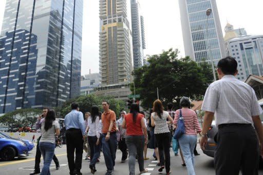 Workers cross the road in the central business district of Singapore in 2011. (AFP photo)