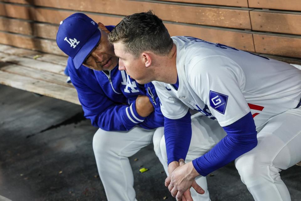 Dodgers manager Dave Roberts talks to pitcher Walker Buehler during a loss to the Colorado Rockies.