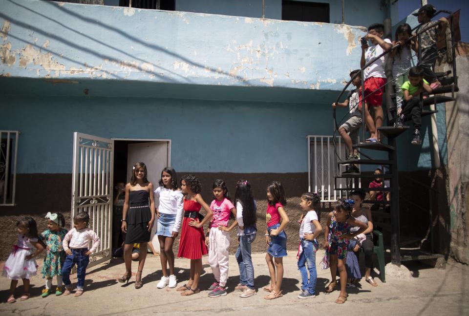 Contestants between the ages of 3 and 12 compete in a homespun beauty pageant in the Antimano neighborhood of Caracas, Venezuela, Friday, Feb. 5, 2021. Neighbors in the hillside barrio gathered for the carnival pageant tradition to select their child queen for the upcoming festivities. (AP Photo/Ariana Cubillos)