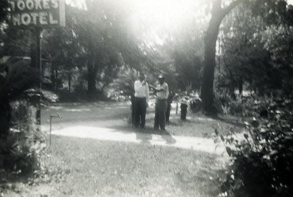 Elihu McCoy standing with another man in front of Tookes Hotel in Frenchtown. The Tookes Hotel was established in 1948 by James and Dorothy Tookes as lodging for African-American travelers visiting segregated Tallahassee. The hotel was located in Frenchtown and remained in operation until the 1980s.