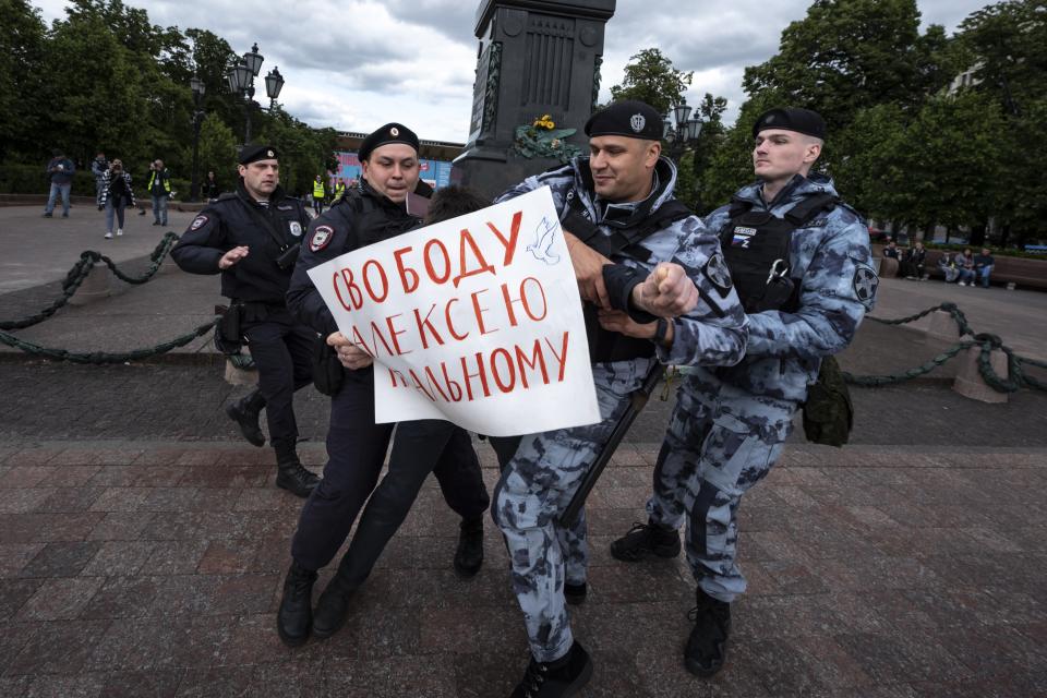 FILE - Police officers detain a demonstrator with a poster that reads: "Freedom for Alexei Navalny", in Pushkinskaya Square in Moscow, Russia, Sunday, June 4, 2023. Most Russian opposition figures are either in prison at home or are in exile abroad. But they vow that they will still put up a fight against President Vladimir Putin as he seeks yet another term in office in an election scheduled for March. (AP Photo, File)