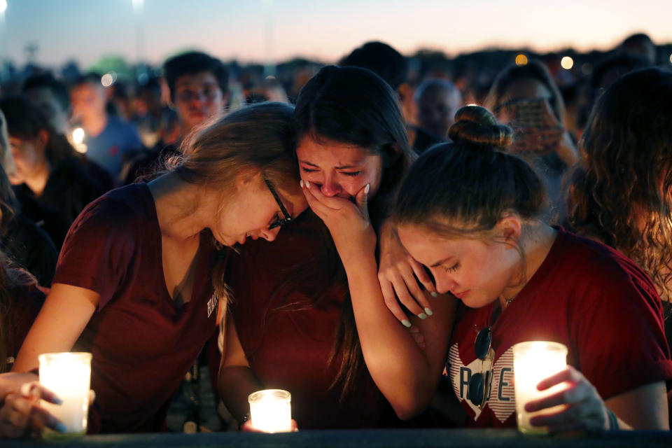 Students hold a vigil for the victims at Marjory Stoneman Douglas High School on Feb. 15, the day after the shooting. (Photo: Gerald Herbert/AP)