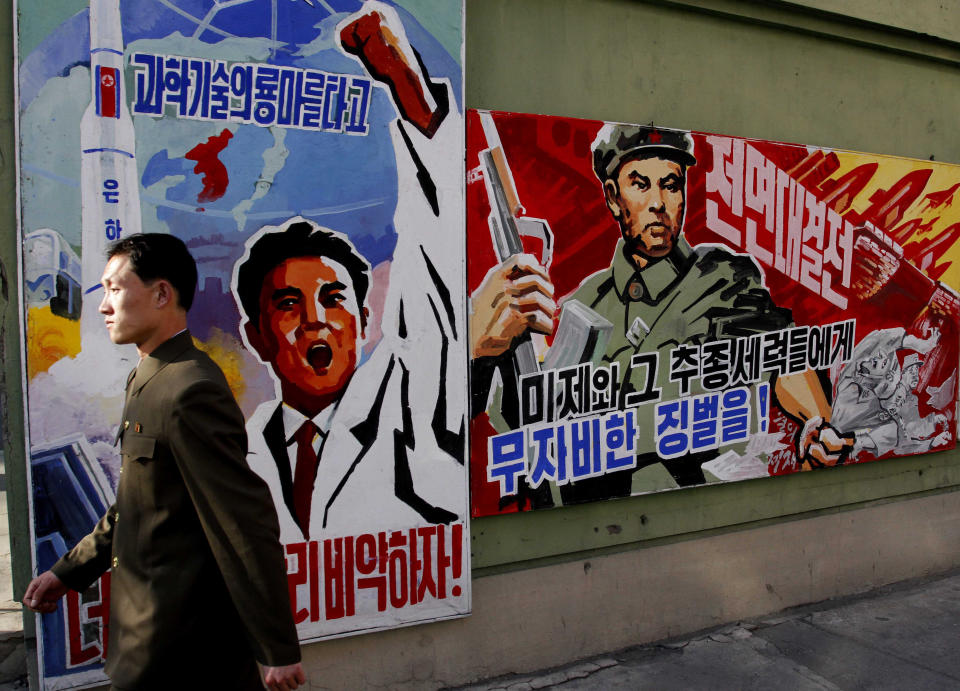 FILE - In this March 26, 2013 file photo, a North Korean man walks past propaganda posters in Pyongyang, North Korea, that threaten punishment to the "U.S. imperialists and their allies." North Korea’s propaganda machine is churning out near-daily diatribes against the United States and South Korea for a series of soon-to-start military maneuvers, warning nuclear war could be imminent and saying it will take dramatic action of its own if further provoked. (AP Photo/Kim Kwang Hyon, File)