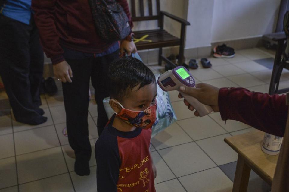 A pre-schooler has his temperature checked on his first day back at school in Putrajaya July 1, 2020. — Picture by Shafwan Zaidon