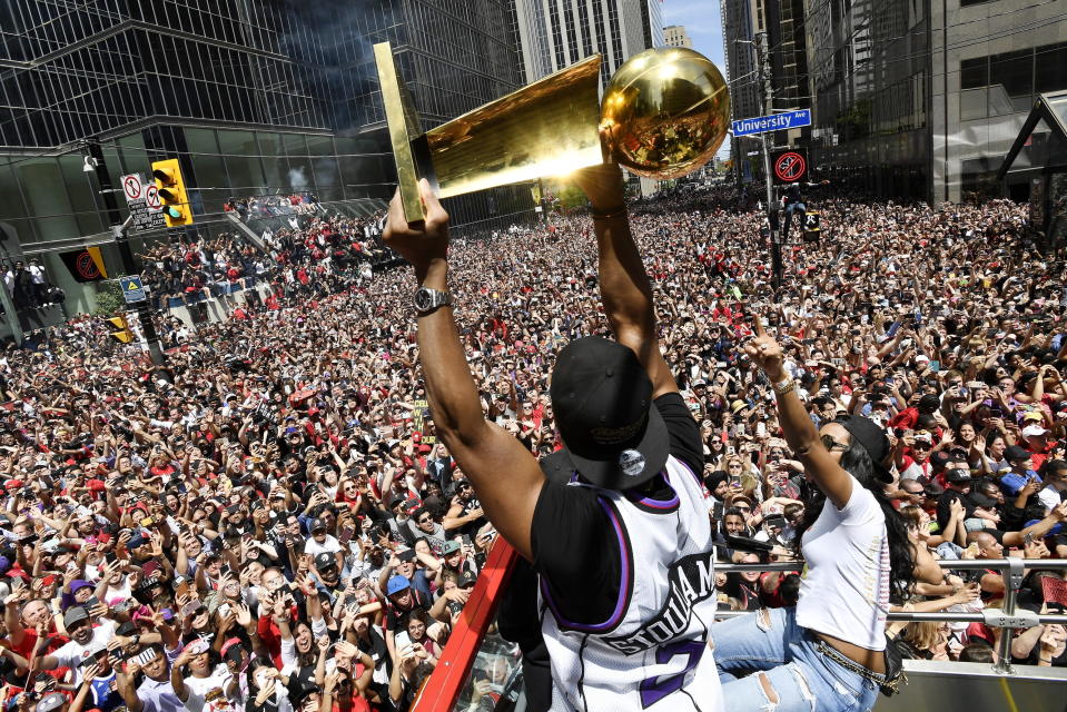 Toronto Raptors guard Kyle Lowry holds the Larry O'Brien Championship Trophy up for the fans during the NBA basketball championship team's victory parade in Toronto, Monday, June 17, 2019. (Frank Gunn/The Canadian Press via AP)