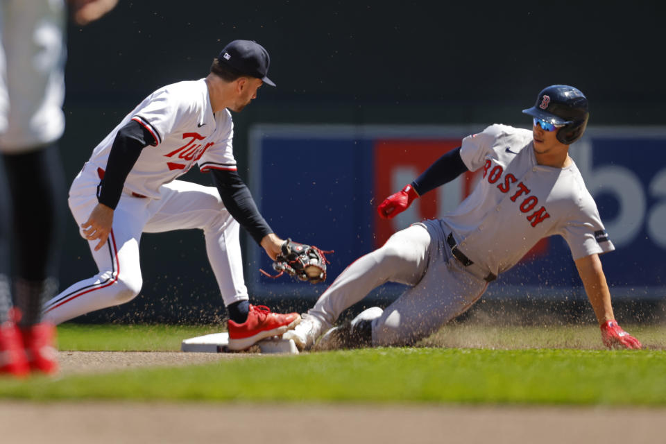 Boston Red Sox's Rob Refsnyder, right, beats a tag by Minnesota Twins second baseman Edouard Julien for an RBI double in the fourth inning of a baseball game Sunday, May 5, 2024, in Minneapolis. (AP Photo/Bruce Kluckhohn)